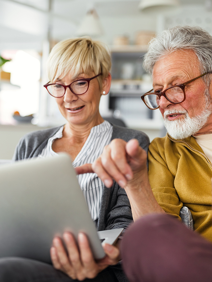 Older woman and man looking at laptop