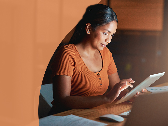 Woman in orange looking down at tablet